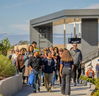 Student leading a campus tour in front of the Otter Student Union