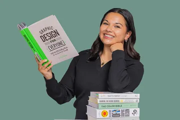 Gracie leaning on stack of books and reading a book