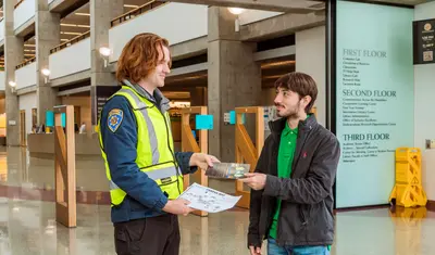 A CSUMB Community Service Officer shares a campus map with a student.