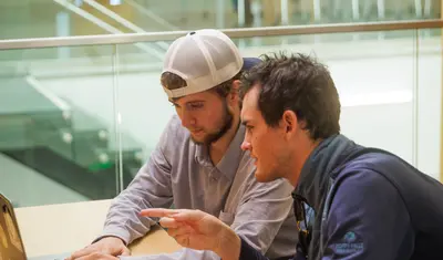 Two male students looking at laptop screen