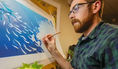 Student painting a seascape