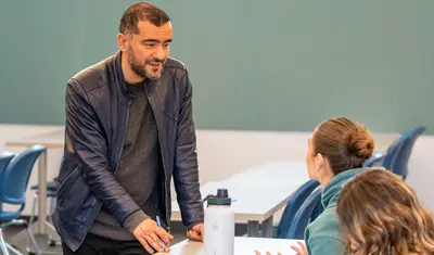 Teacher having conversation with student at desk