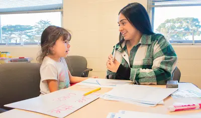 Ashley Arango, right, works with Emely Hernandez at the Reading Center.