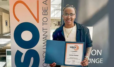 Basketball player holding WBCA certificate