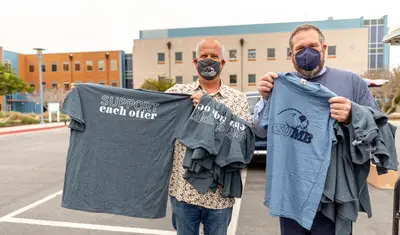 Photo: Chip Lenno and Andrew Drummond holding t-shirts that say 