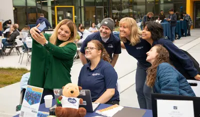 President Quiñones taking a selfie with staff and student assistants at the Brunch with the President event