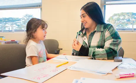 Ashley Arango, right, works with Emely Hernandez at the Reading Center.