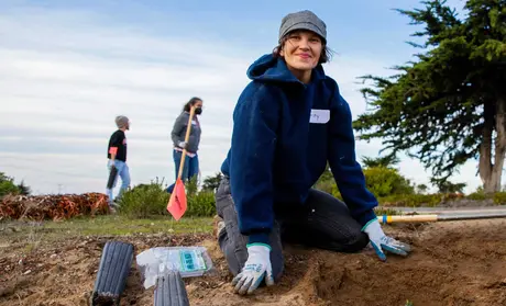 Lacey Raak planting coast live oak trees during the Habitat Restoration and Tree Planting event