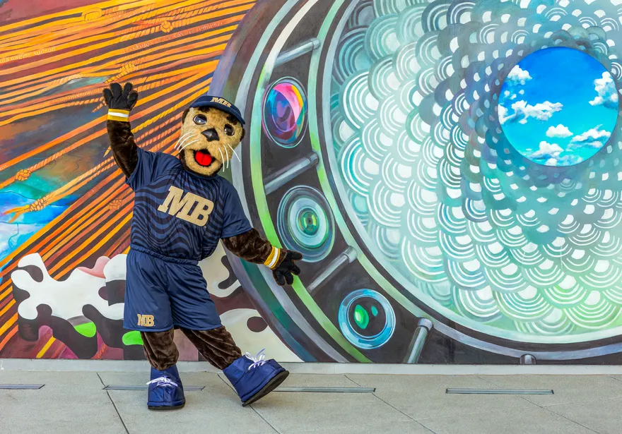 Monte in front of colourful mural
